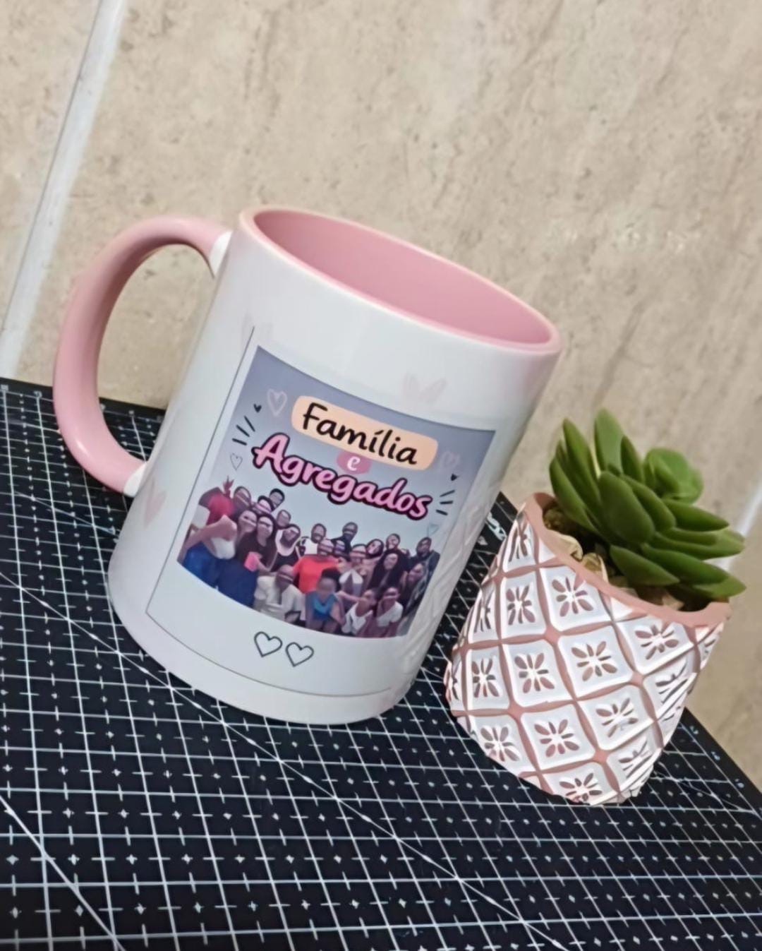 Caneca branca com interior e alça rosa, foto de família em grupo e o texto Família e Agregados