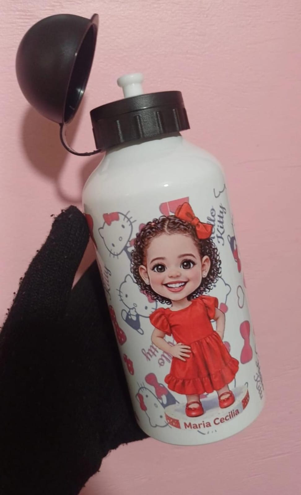 Squeeze branco infantil com caricatura de menina de cabelo cacheado, laço e vestido vermelhos, fundo da Hello Kitty e o nome Maria Cecilia